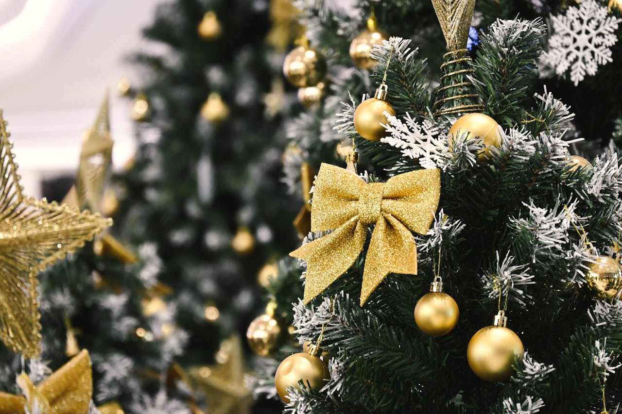 home-services-004 Elegant Christmas tree adorned with gold ornaments and a sparkling bow, capturing the holiday spirit in a festive setting.